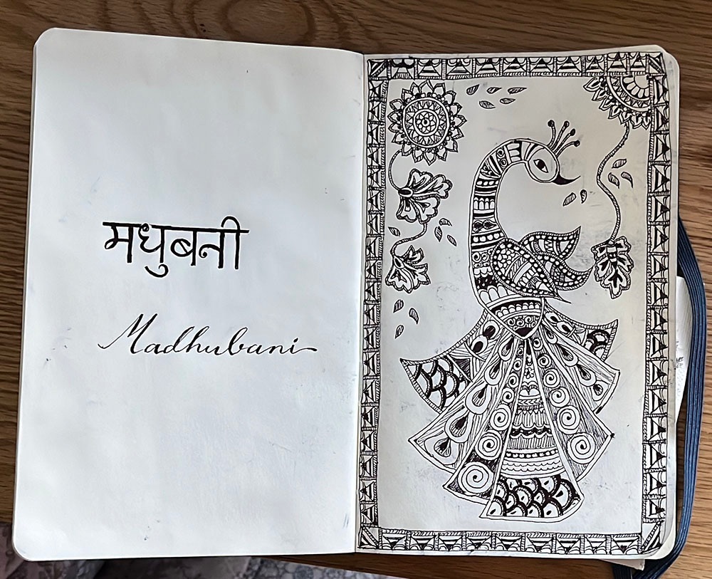 A notebook with calligraphy and an ornate sketch of a bird