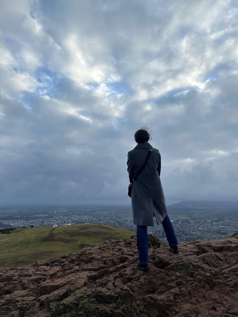 Cate standing atop a mountain in England looking over a town