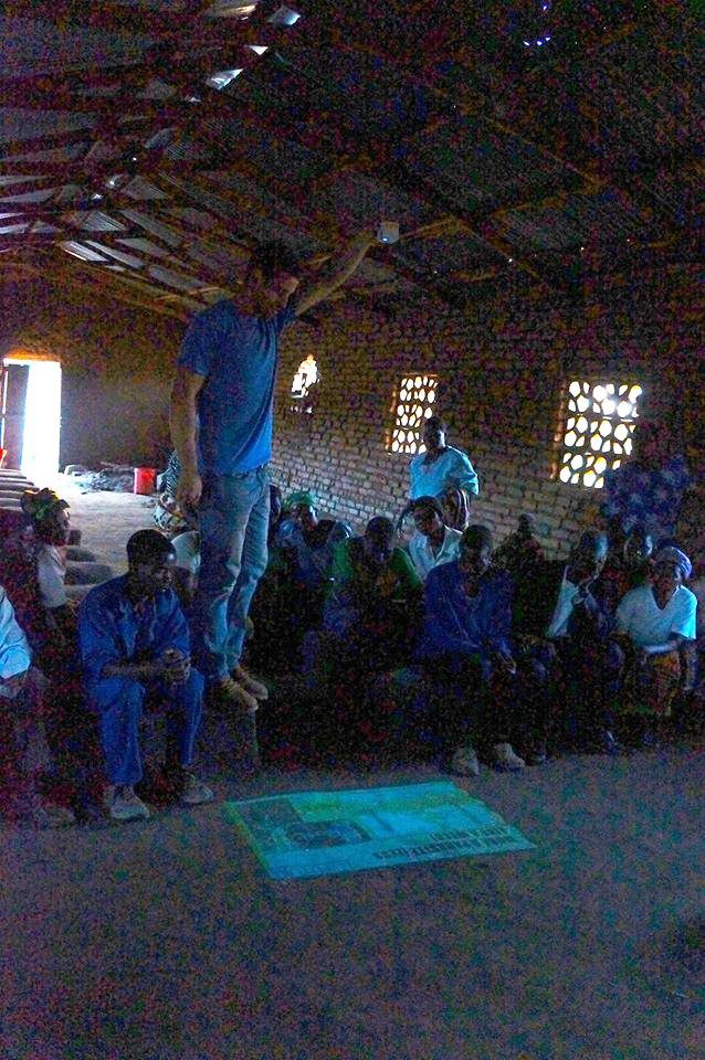 Silberg projects information on the floor in a meeting of Malawian farmers.