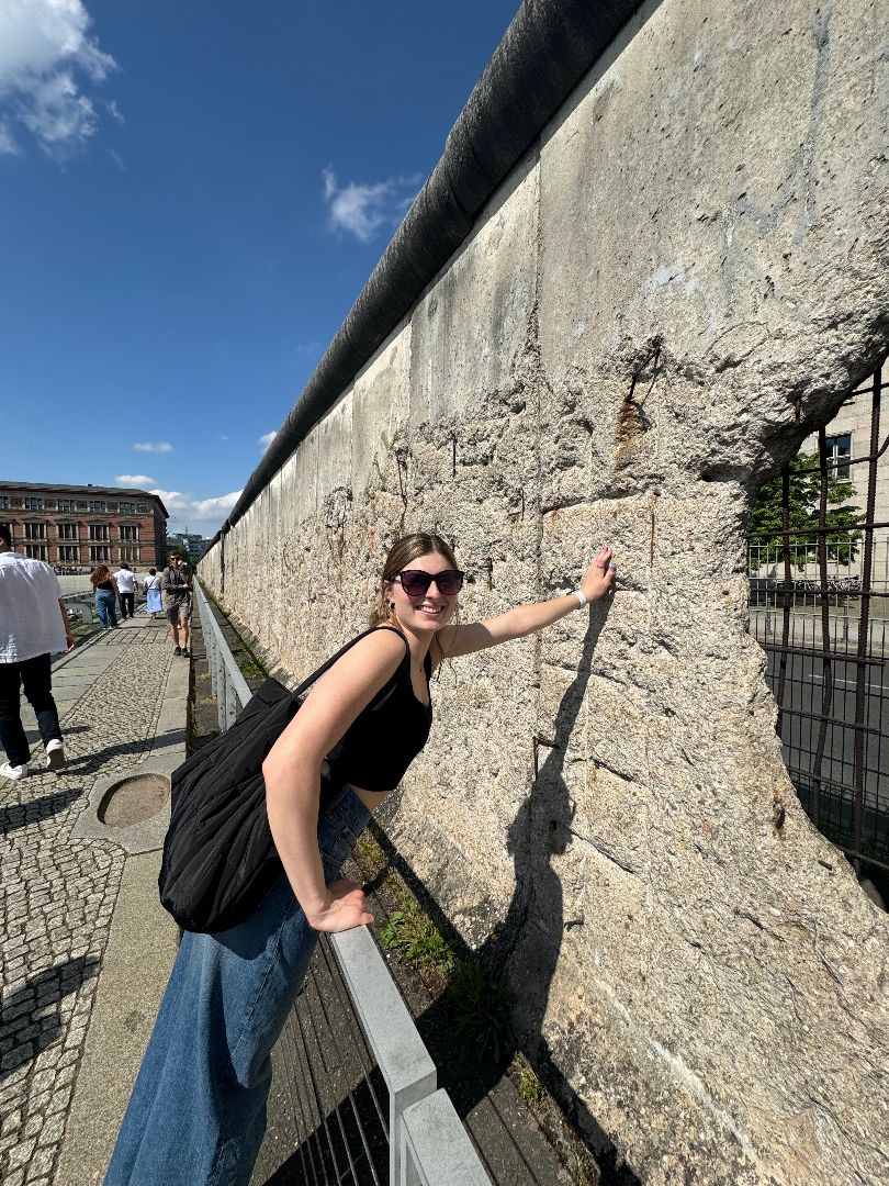 Sarah touching the Berlin Wall