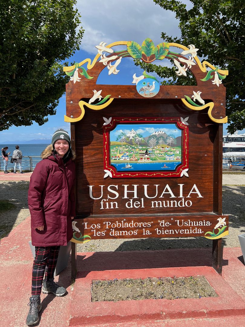 Sierra in front of Ushuaia sign in Argentina