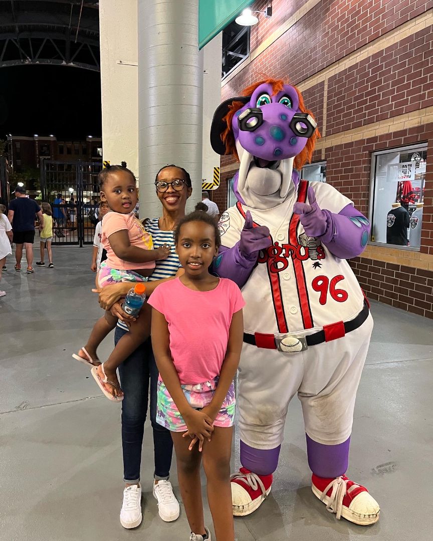 Dr. Mogale and her children with the Lansing Lugnuts mascot. 