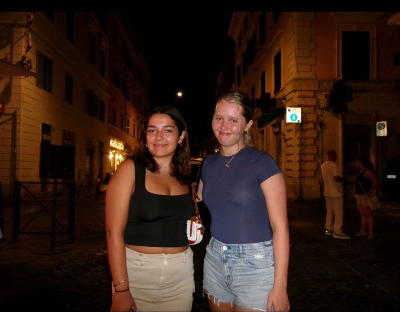 Riley and friend posing on a local street at night in Italy