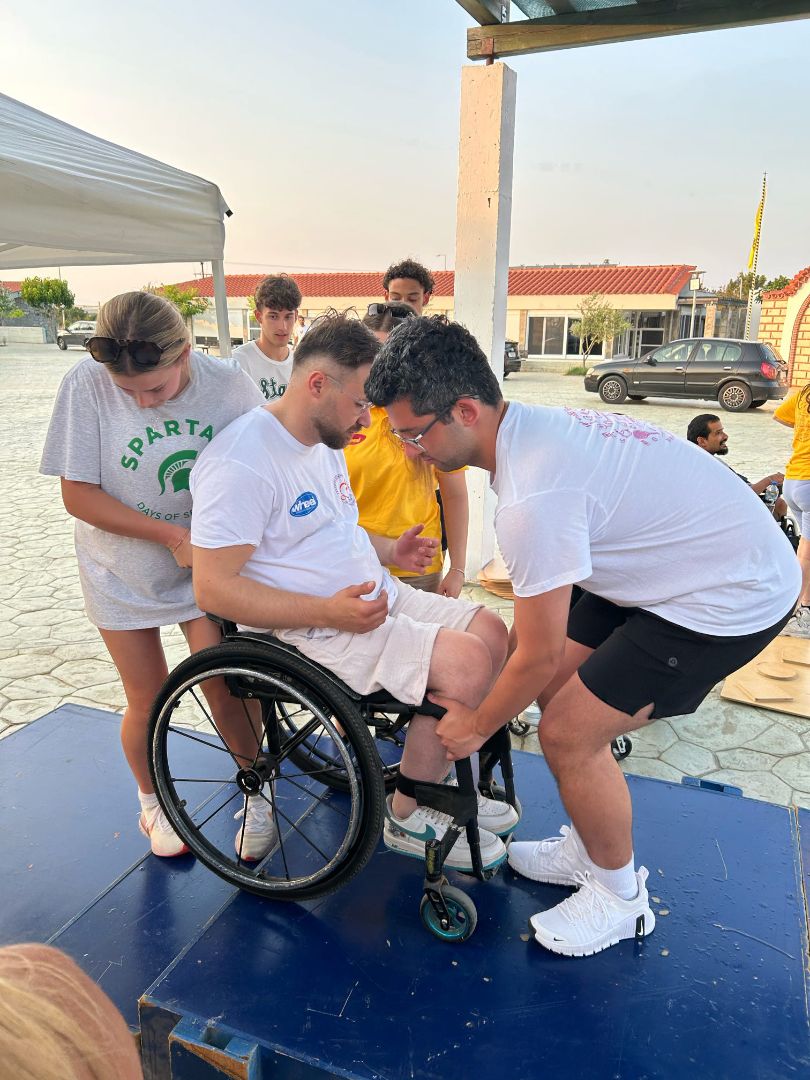 Sydney and another student assisting a person in a wheelchair