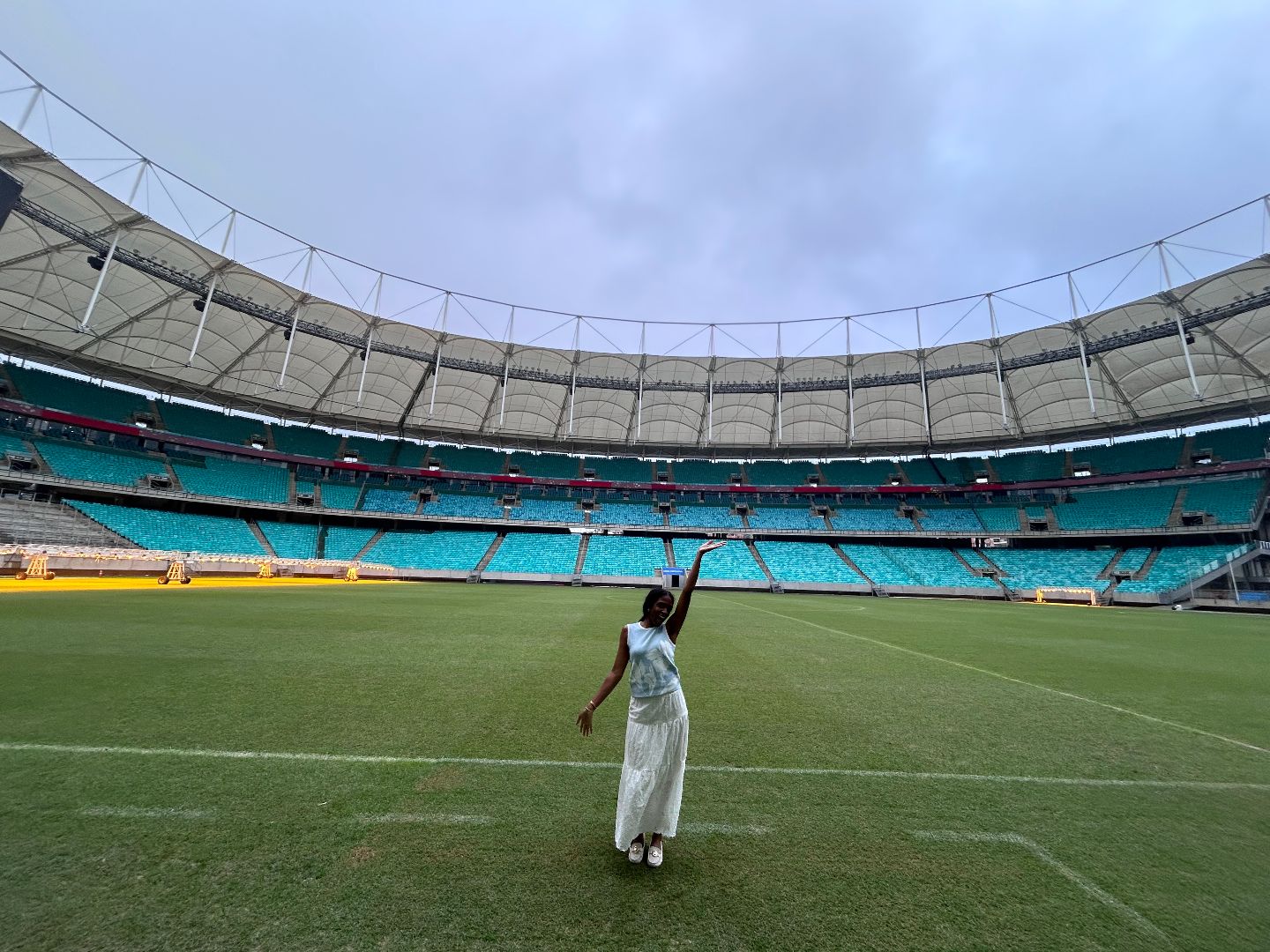 Antrice standing in the field of a large soccer stadium in Brazil