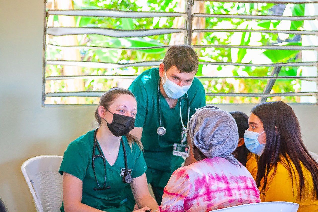Benjamin listening to patients with fellow student in the Dominican Republic