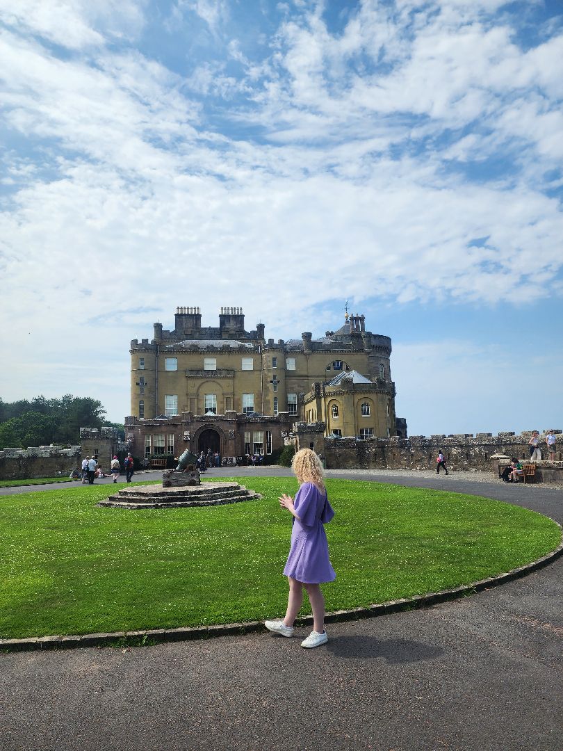 Kiara wearing a purple dress walking in front of a building at the University of Glasgow in Scotland