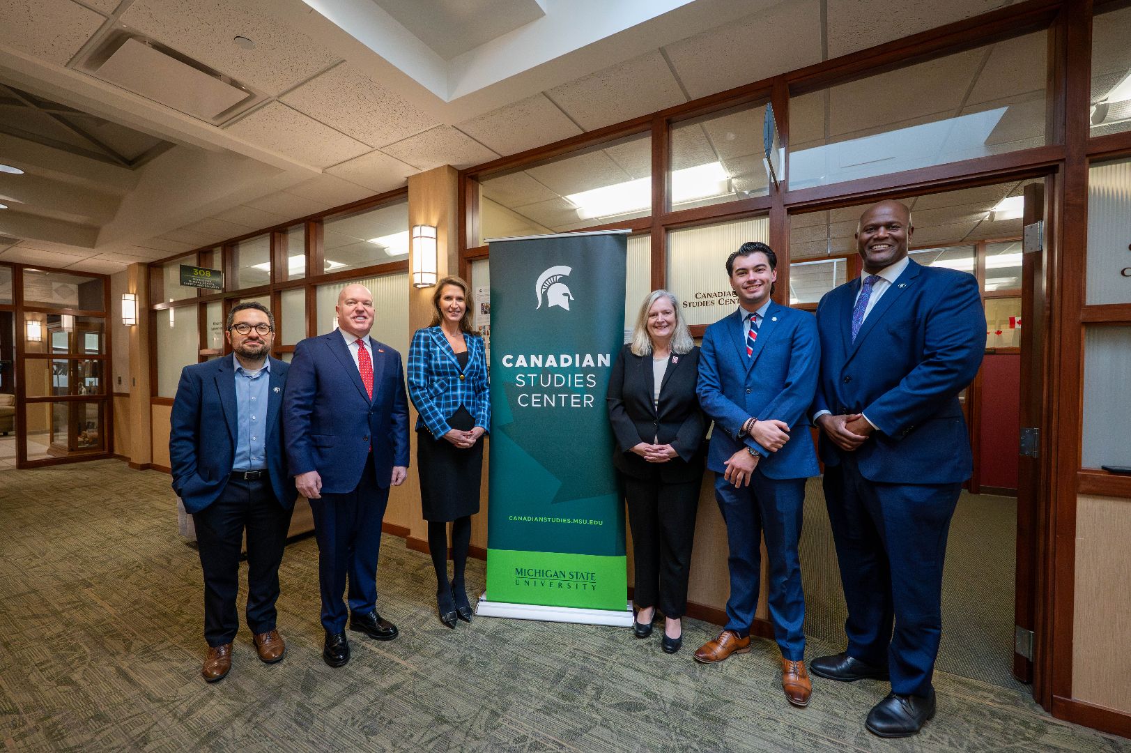 MSU, Ontario, and Michigan leaders posing for a photo outside of the Canadian Studies Center Office.