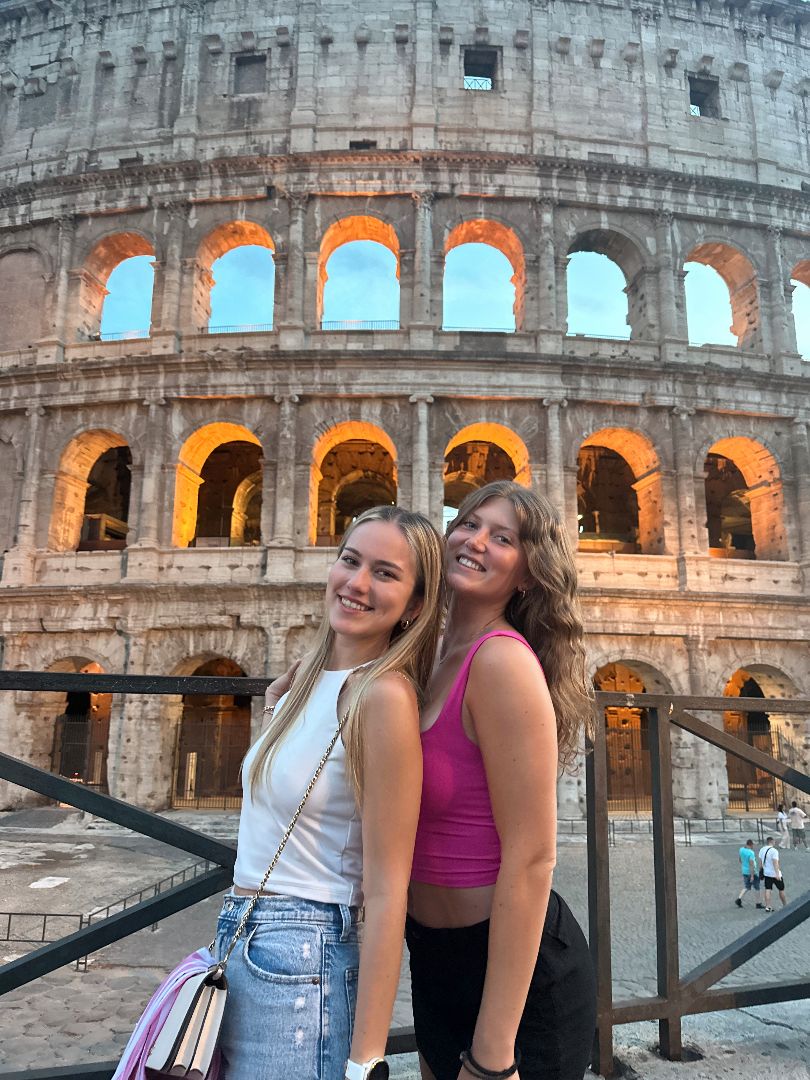 Elizabeth and friend standing in front of the Roman Colesium at dusk