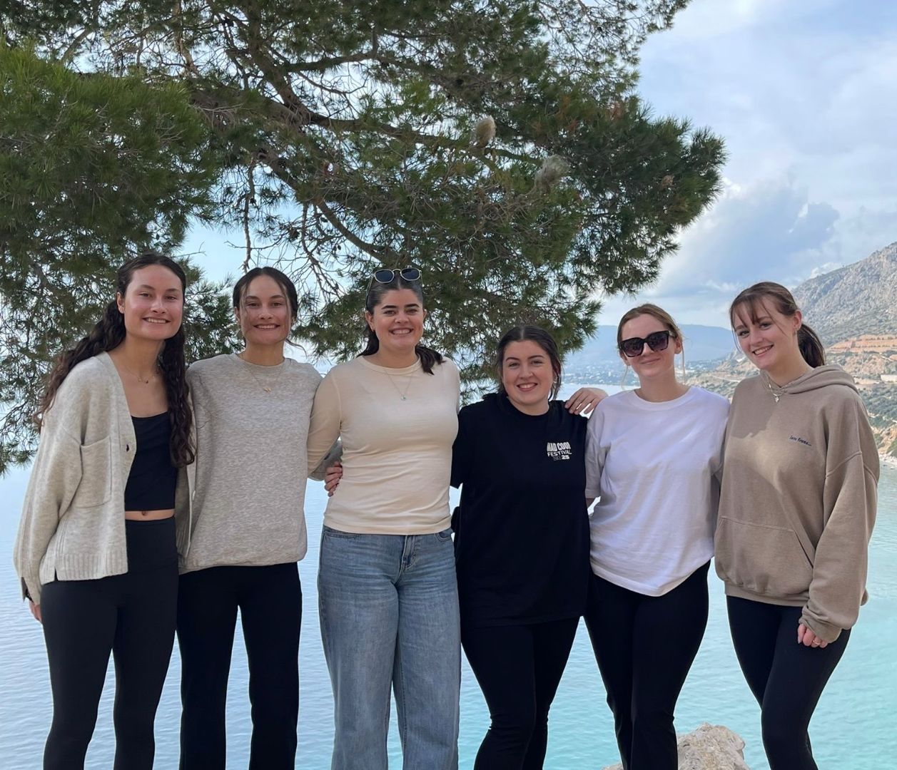 A group of people standing in front of an ocean
