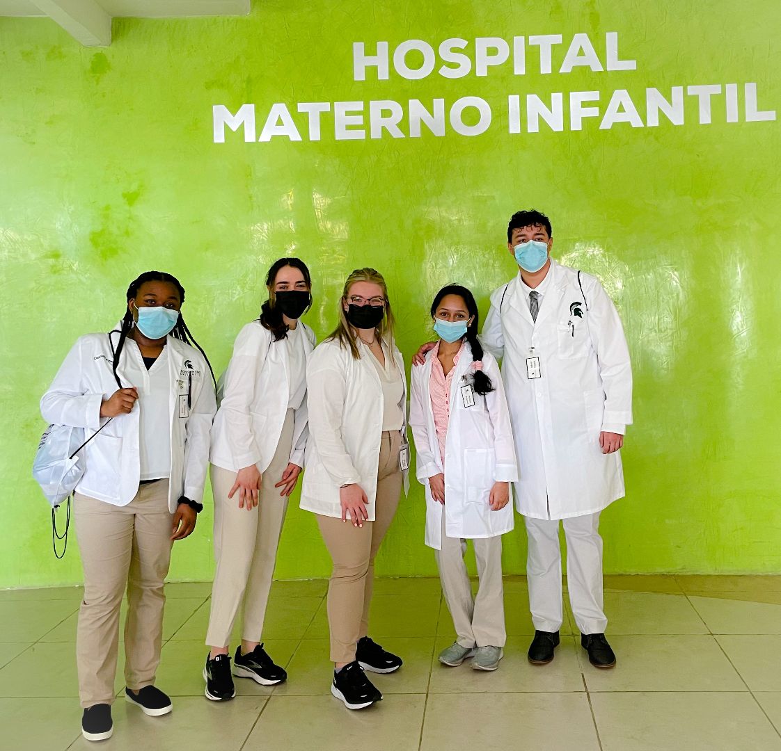 Group of MSU students wearing white lab coats in front of the Hosptial Materno Infantil in Mexico
