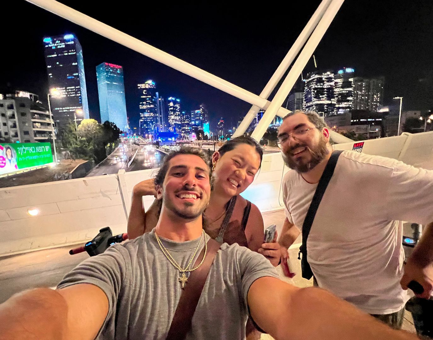 Luke and friends at night taking a selfie on a bridge in Israel