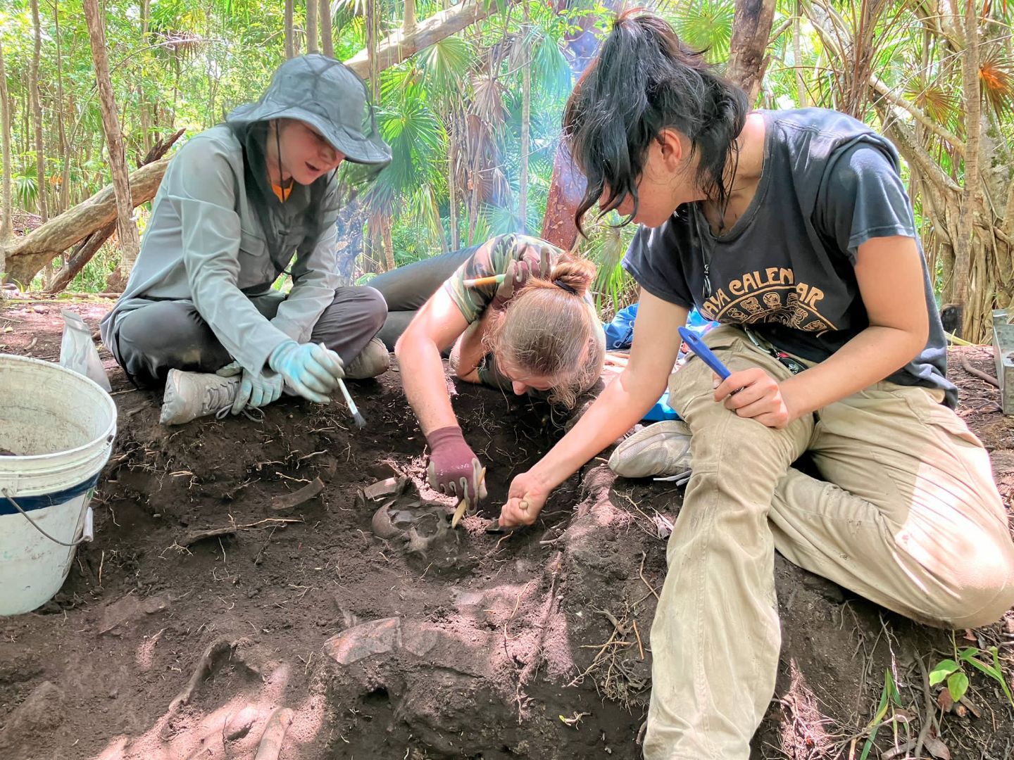 Student at excavation site digging in ground