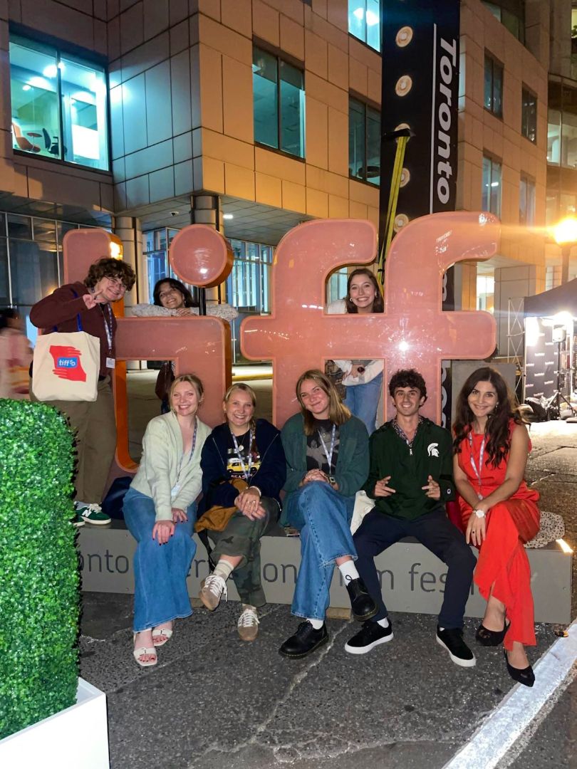Lexi and friends pose on the TIFF sign at night