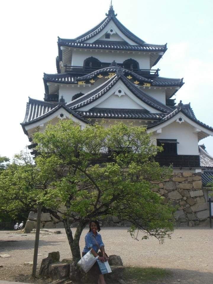 A woman sitting in front of Hikone castle