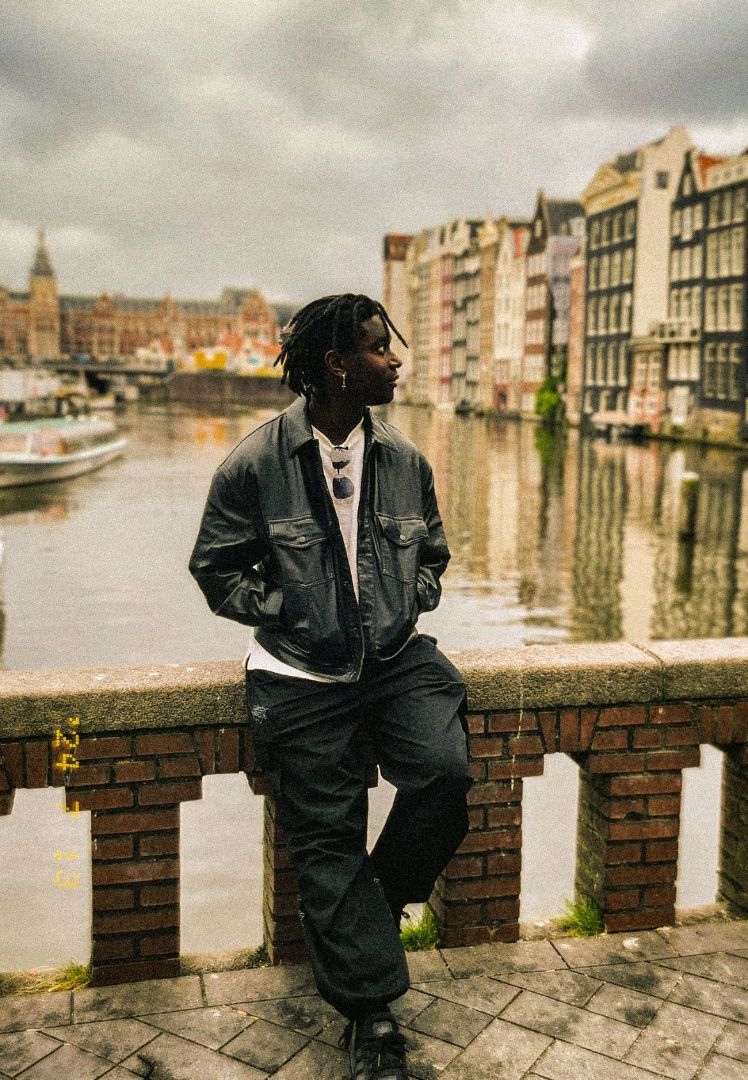 Clifton standing on a bridge over a canal in Europe