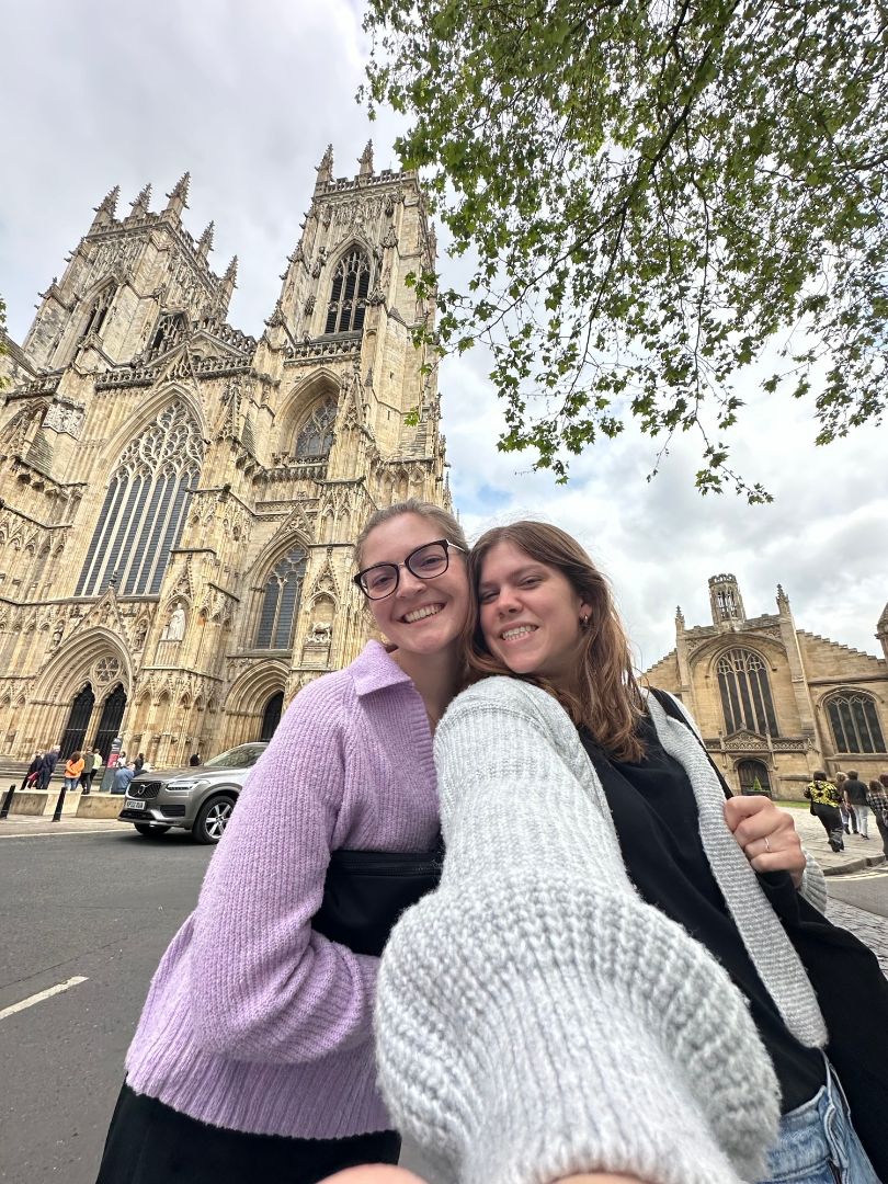 Grace with friend taking a selfie in front of Westminster Abbey