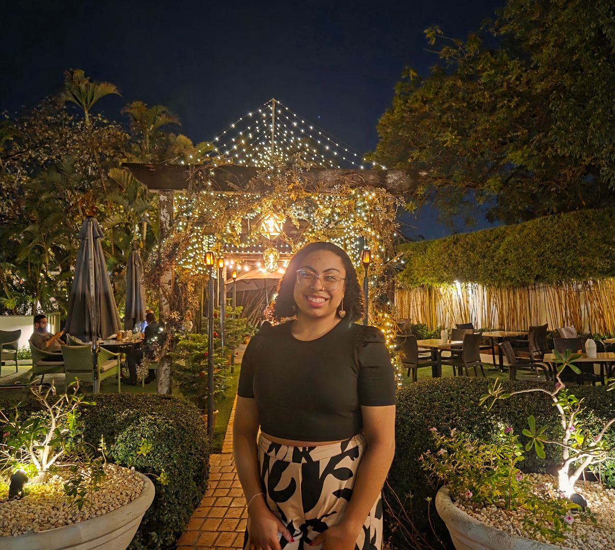 Amirah posing in front of a lighted gazebo at night