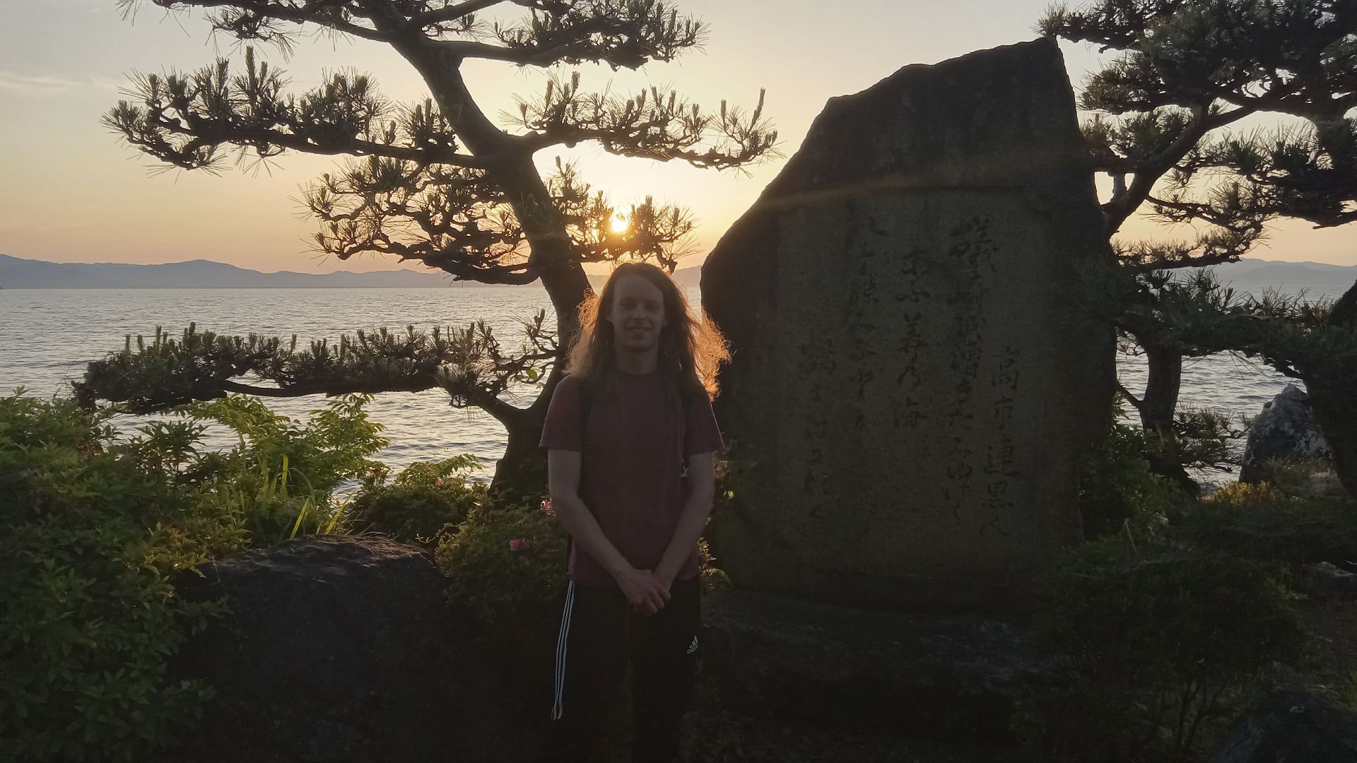 McKee standing on the shore of Lake Biwa during a sunset