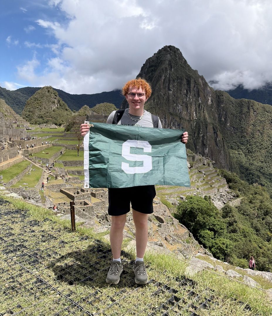 Jagger holding a Spartan flag while standing in Machu Pichu