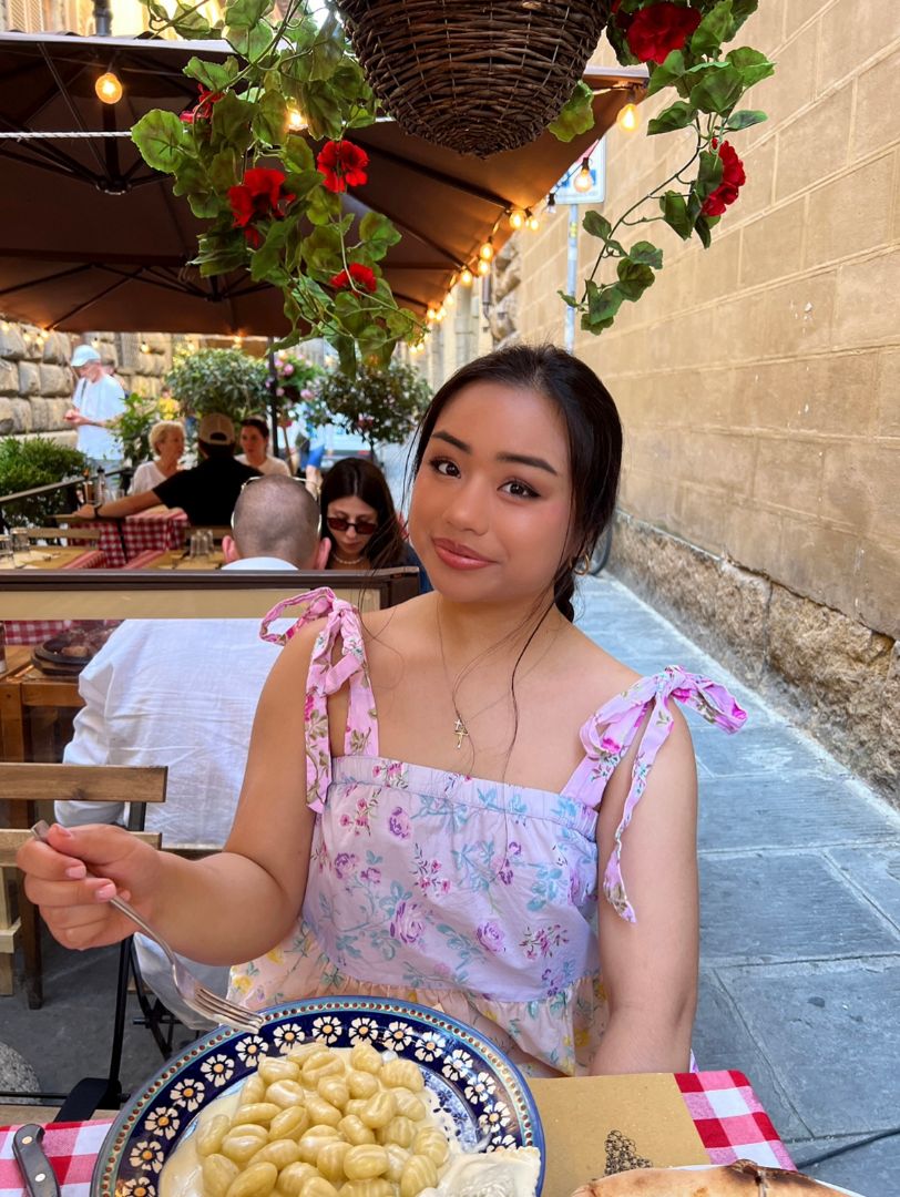 Leslie eating pasta dish in outdoor restaraunt in Italy
