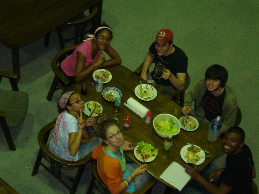 Students looking up for a picture while eating dinner