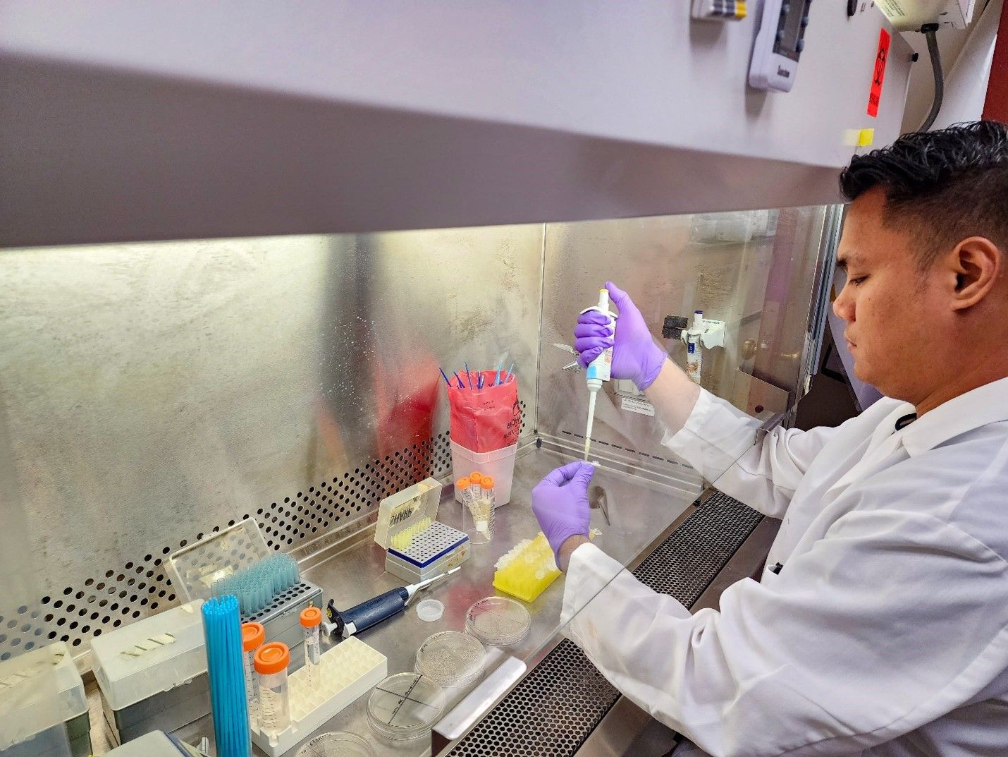 Image of a man in a white lab coat working in a laboratory