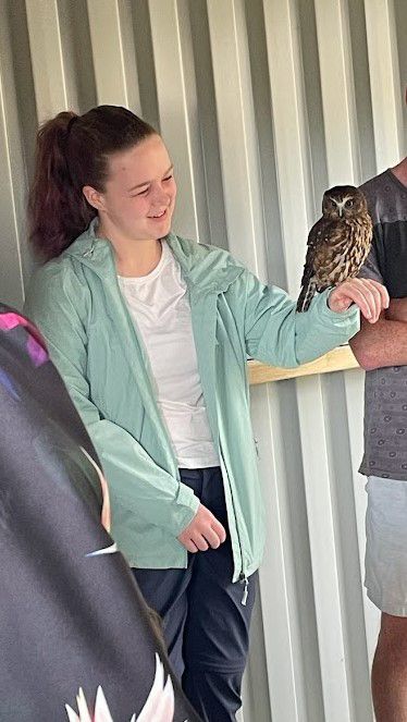 Emily holding an owl on her arm in New Zealand