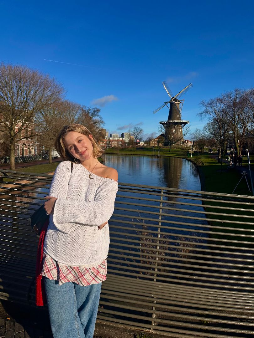 Breanne standing in front of a canal with a windmill in the background