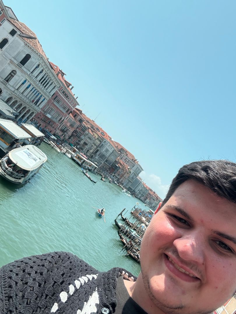 Logan taking a selfie with the canals of Venice behind him