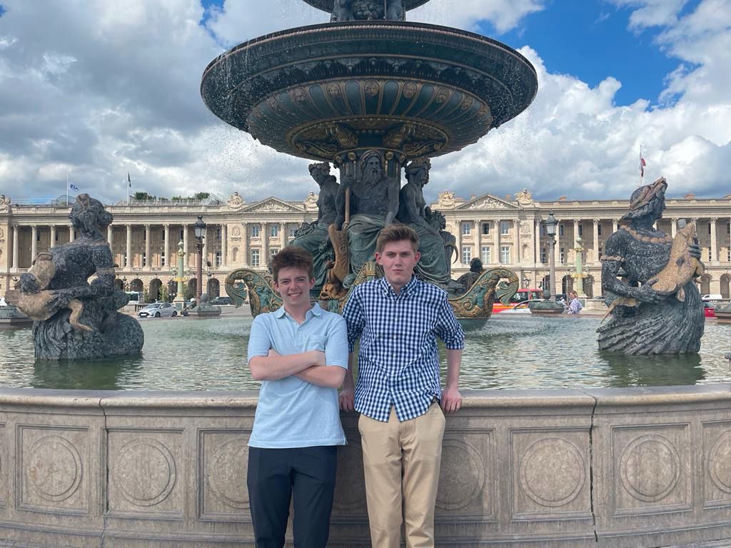 Nicholas standing with another student in front of fountain