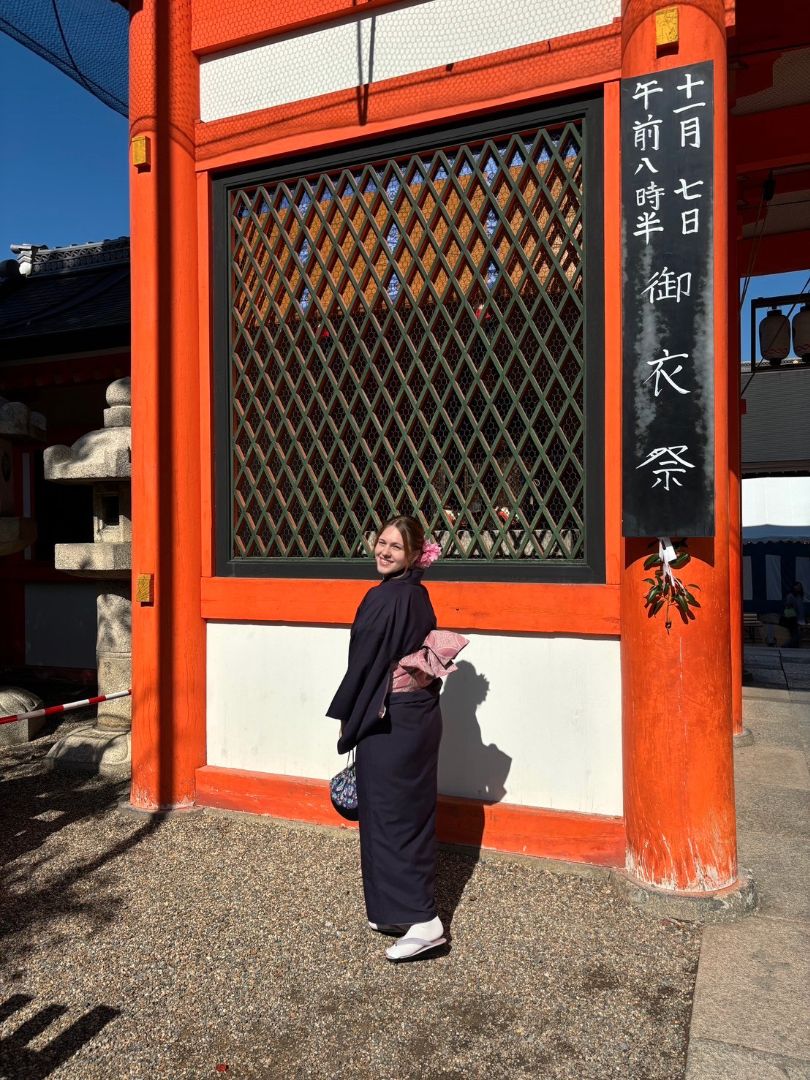 Charlotte wearing a kimono standing in front of a Japanese sign