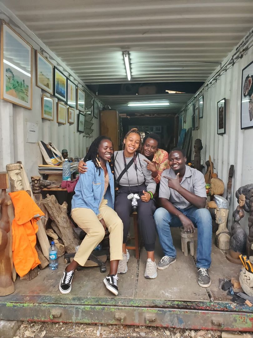 Lily with students and local inside a semi trailer that has art and artifacts inside