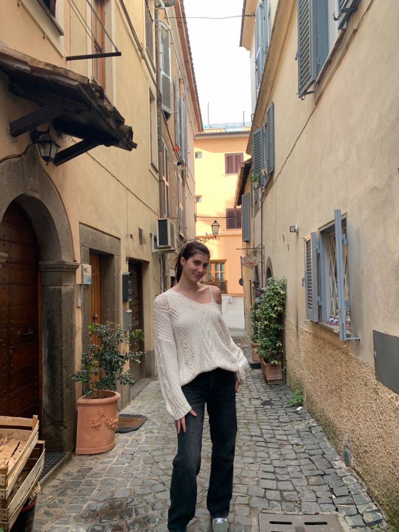 Adelle posing on cobblestone street in Italy