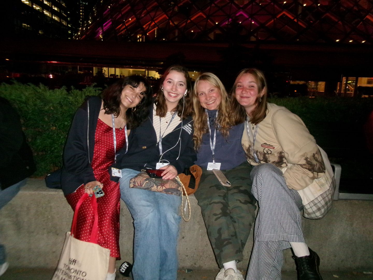 Tess and friends sitting on a concrete wall at night in Toronto