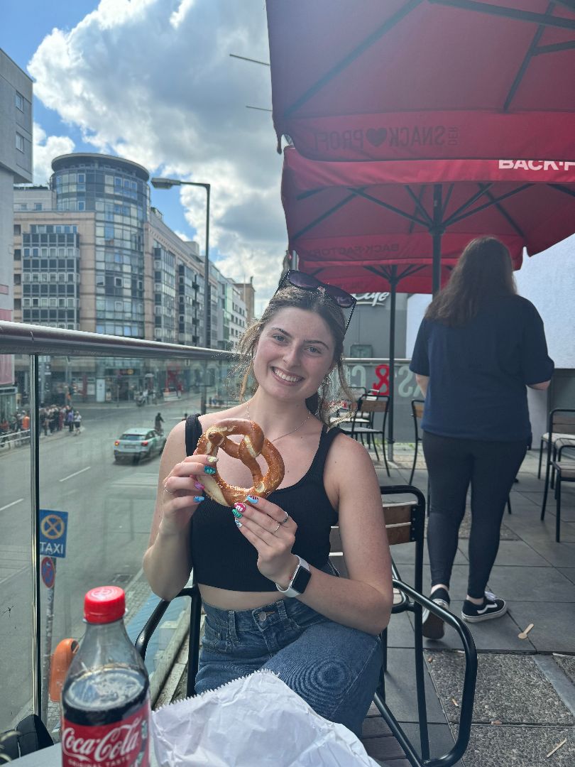 Sarah eating a pretzel at a street cafe in Germany