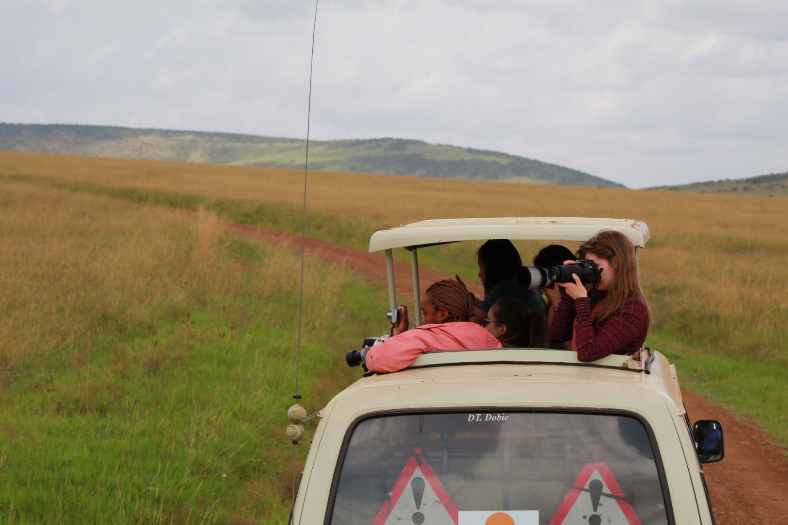 Students taking photo from Jeep on a safari in Kenya