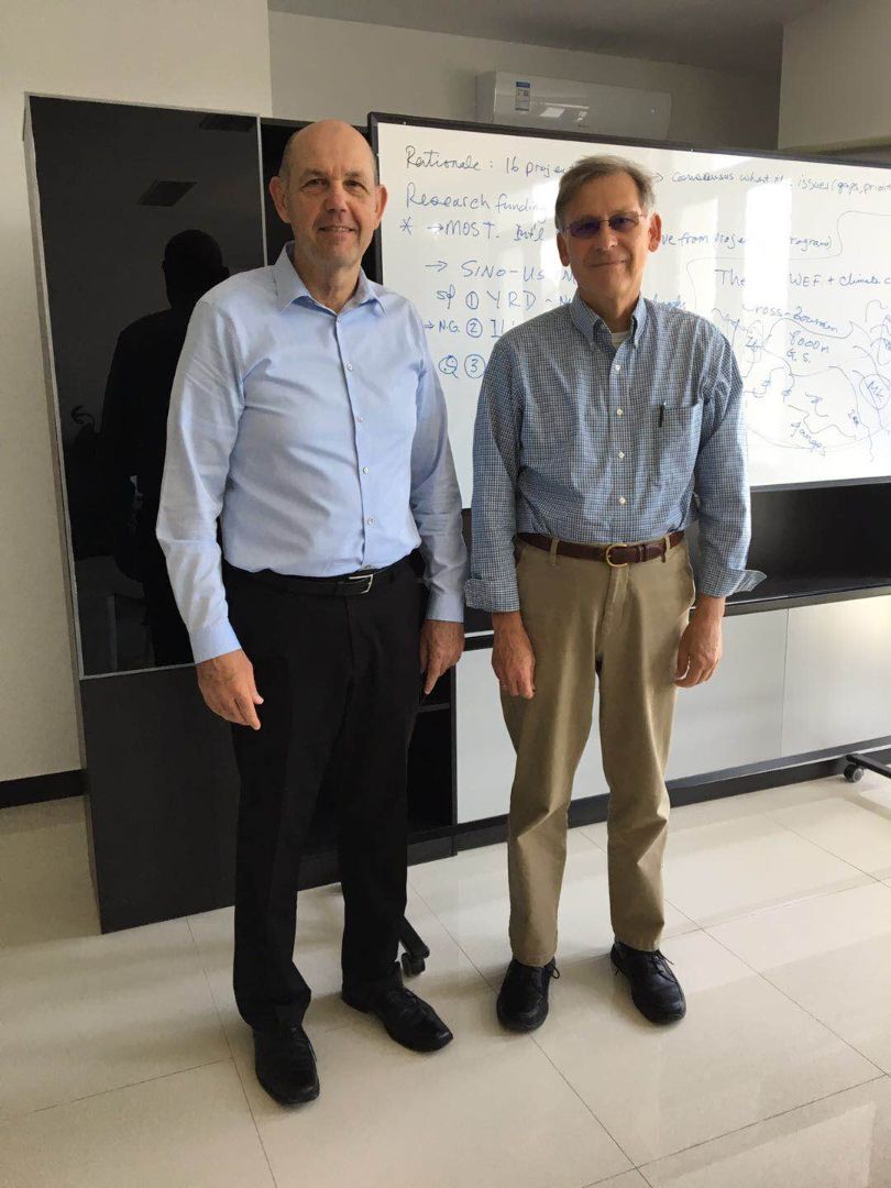 Two men posing in front of a whiteboard