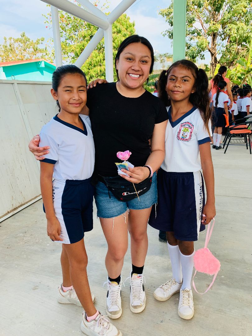Maria posing with local school children in Mexico