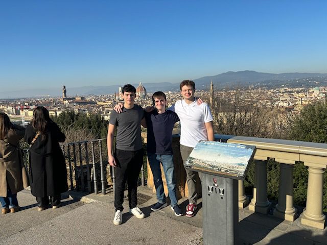 Andrew and friends posing for a picture with city of Florence in the background