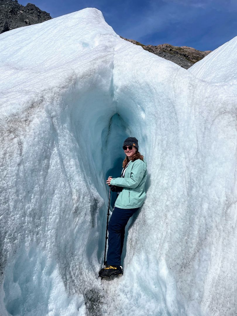 Emily standing inside a small cave on a glacier