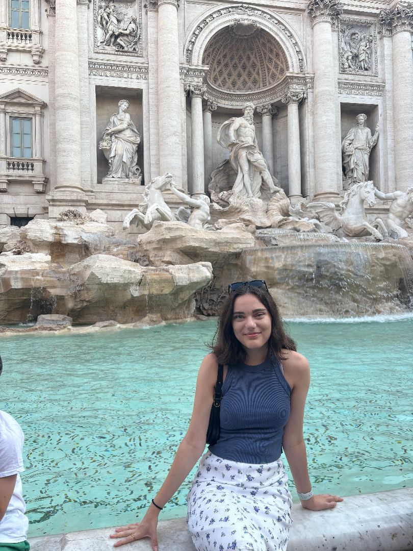 Abigail sitting at the Trevi Fountain in Rome