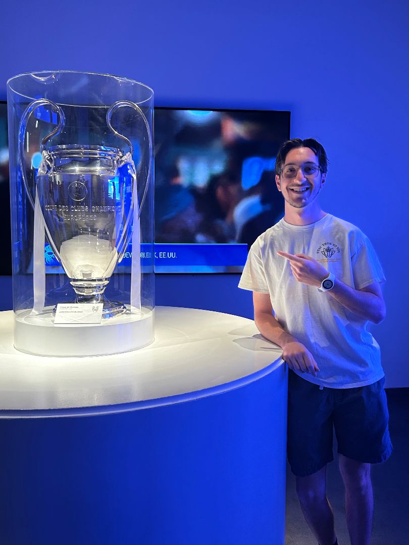 Evan pointing to a large silver trophy