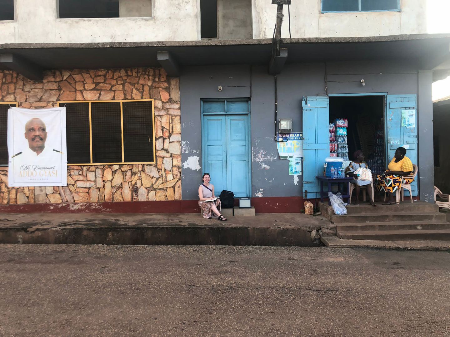 Jenna sitting in front of a clinic in Ghana