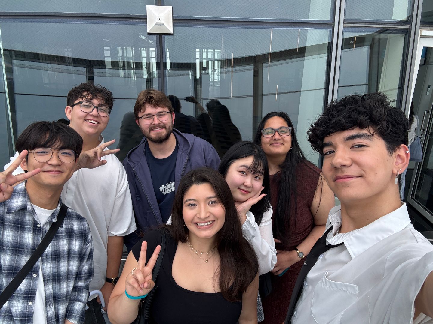 Noah and friends pose for a photo in a glass elevator