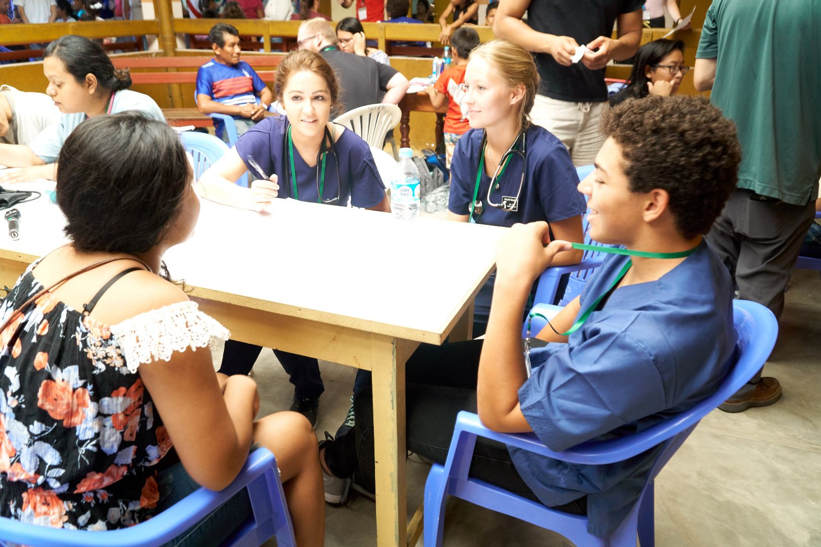 MSU medical students sitting at table talking to local Peruvians