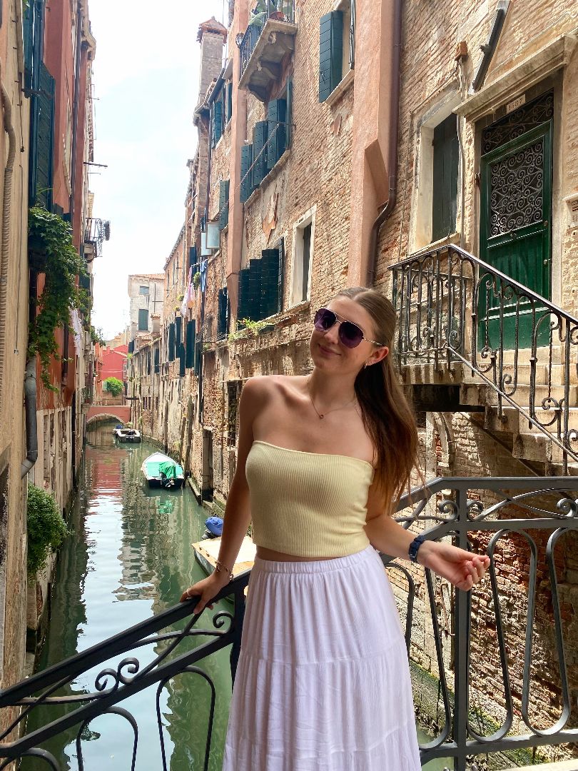 Madelynn posing with sunglasses in front of a canal in Italy