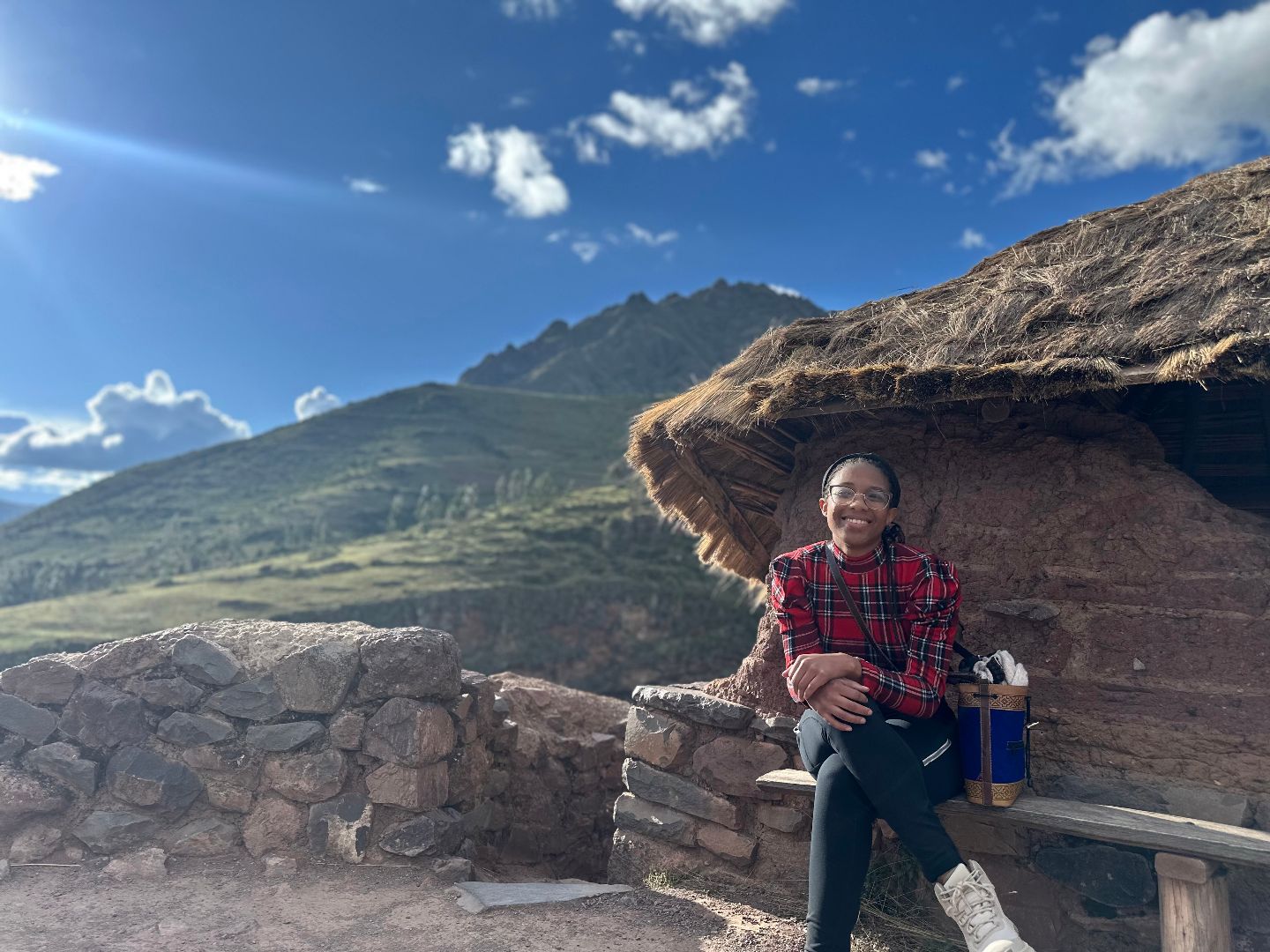 Asha sitting on a wooden bench within Machu Pichu