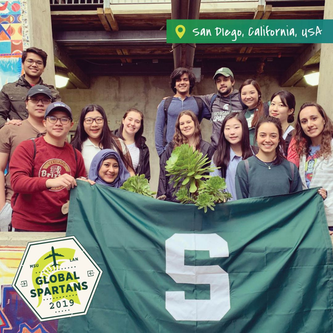 Global Spartans pictured in a group standing on a step posing for a picture in San Diego, CA