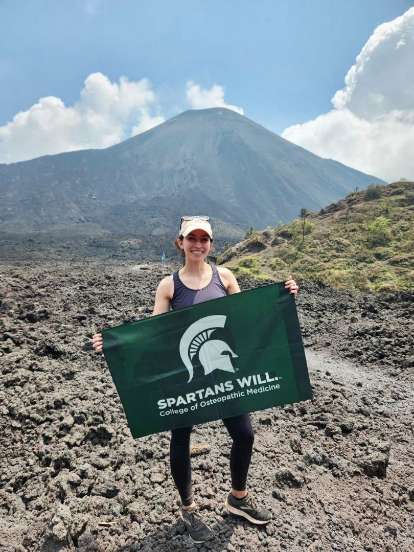 Maria holding Spartan flag in mountainous area of Guatemala